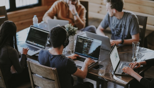 Group of content creators brainstorming social video ideas on laptops